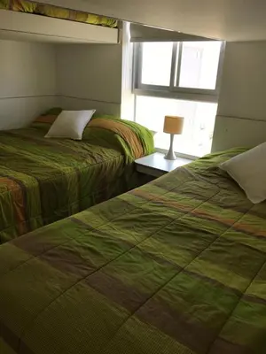 a bedroom with two beds and a window at Paracas departamento Condominio Nautico in Paracas