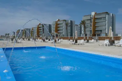 a pool with water faucets in front of a resort at Paracas departamento Condominio Nautico in Paracas