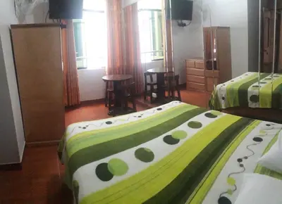a bedroom with two beds with green and white sheets at Hostal Sueños in Lima