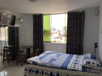 a bedroom with a bed and a large window at Hostal Sueños in Lima