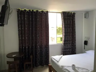a bedroom with a bed and a window with curtains at Hostal Sueños in Lima