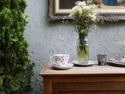 a table with a vase of flowers and a cup and plates at Quinta Miraflores Boutique Hotel in Lima