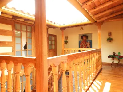 a room with a balcony with wooden chairs at Picaflor Tambo Guest House in Ollantaytambo