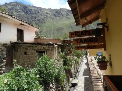 a street with signs on the side of a building at Picaflor Tambo Guest House in Ollantaytambo