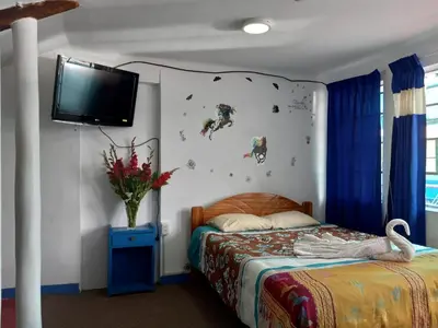 a bedroom with a bed and a tv on a wall at Posada Azul Cusco in Cusco