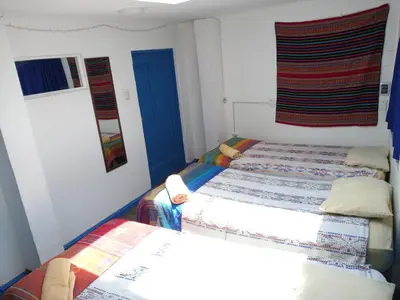 a bedroom with two twin beds and a window at Posada Azul Cusco in Cusco