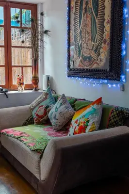 a couch with pillows on it in a living room at Posada Azul Cusco in Cusco