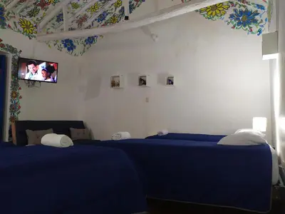 a bedroom with two blue beds and a tv at Apartamento Cusco Queswa in Cusco