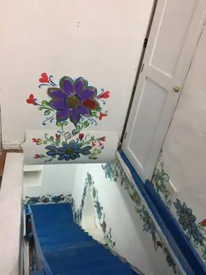 a door with a flower painted on the wall at Apartamento Cusco Queswa in Cusco
