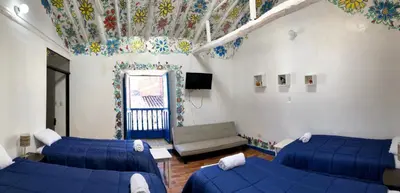 a room with two beds and a couch in a room at Apartamento Cusco Queswa in Cusco
