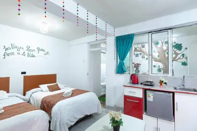 a bedroom with two beds and a sink in it at Magic Cusco in Cusco