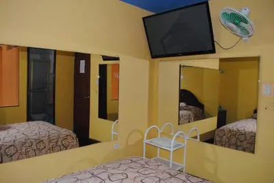 a bedroom with two beds and a flat screen tv at Hotel SKY in Lima