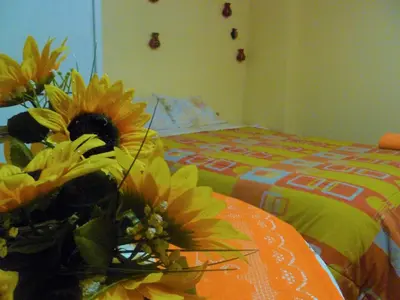 a vase of flowers sitting on a table with a bed at BiosWild in Cusco