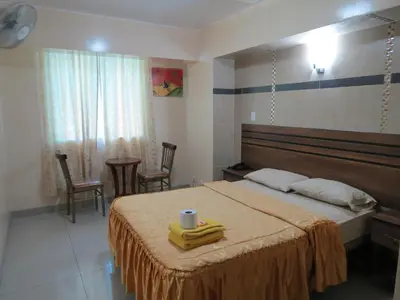 a bedroom with a large bed with a table and chairs at HOTEL ESTRELLA in Lima