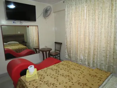 a bedroom with a red bed and a mirror at HOTEL ESTRELLA in Lima