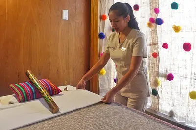 a woman standing in front of a table with a knife at Hotel Monasterio San Pedro in Cusco