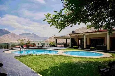 a resort with a pool and mountains in the background at Empedrada Ranch & Lodge - Hotel Asociado Casa Andina in Caral
