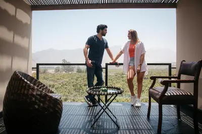 a man and a woman standing on the balcony of a house at Empedrada Ranch & Lodge - Hotel Asociado Casa Andina in Caral
