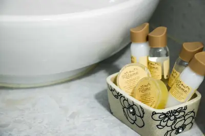 a container with four bottles of essential oils next to a toilet at Hotel Retama Machupicchu in Machu Picchu