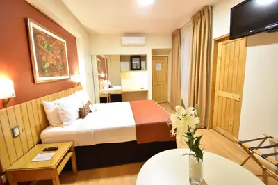a hotel room with a bed and a tv at Qorianka Hotel in Lima