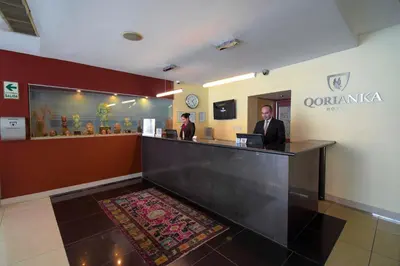 two men standing at a counter in a hotel lobby at Qorianka Hotel in Lima