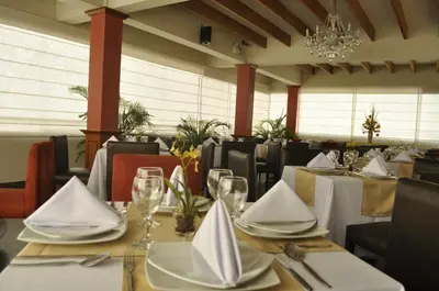 a dining room with tables and chairs and a chandelier at Qorianka Hotel in Lima