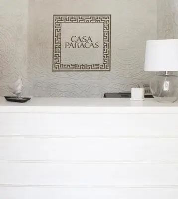 a white dresser with a lamp and a picture at Casa Paracas in Paracas