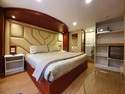 a bedroom with a large bed and a flat screen tv at El Mariscal Cusco in Cusco