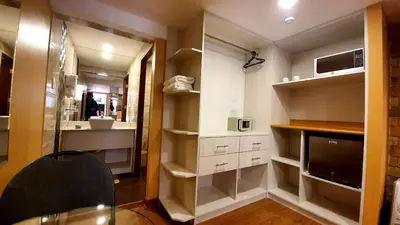 a small kitchen with white cabinets and a mirror at El Mariscal Cusco in Cusco