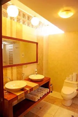 a bathroom with two sinks and a toilet and a mirror at Hotel Waynapicchu in Cusco