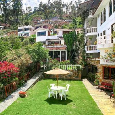 a patio with a table and chairs on the grass at La Mansion Casa Hotel in Andahuaylas
