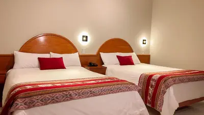 a hotel room with two beds with red pillows at La Mansion Casa Hotel in Andahuaylas