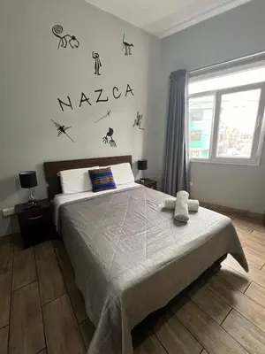 a bedroom with a bed and a window at Lima Airport Tampu in Lima