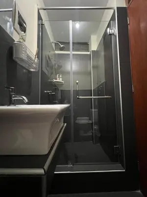 a bathroom with a glass shower and a sink at Lima Airport Tampu in Lima