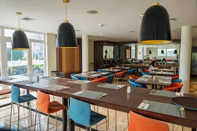 a dining room with tables and chairs and a restaurant at Xima Lima San Isidro in Lima