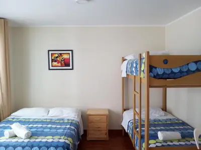 a bedroom with two bunk beds and a ladder at Paracas Backpackers House in Paracas