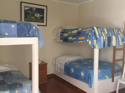 a bedroom with two bunk beds and a bed at Paracas Backpackers House in Paracas
