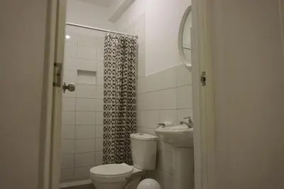 a bathroom with a toilet and a sink and a shower at Hospedaje El Velero in Paracas