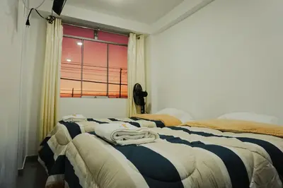 a bedroom with two beds and a window at Hospedaje El Velero in Paracas