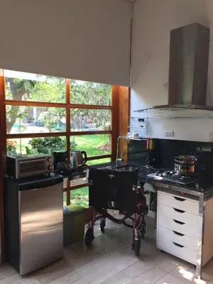 a kitchen with a stove and a large window at Zen Home & Garden House in Cieneguilla