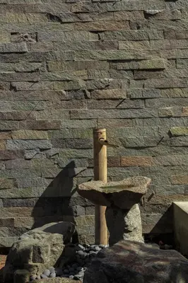 a stone wall with a bird feeder in front at Zen Home & Garden House in Cieneguilla