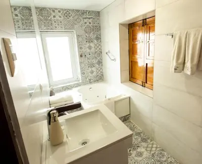 a white bathroom with a sink and a window at Auka Boutique San Blas in Cusco