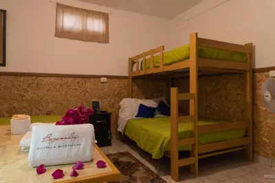 a bedroom with two bunk beds and a table with flowers at BUGANVILIA in Paracas