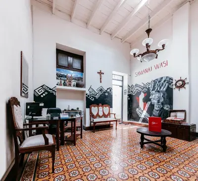 a room with tables and chairs and a wall with a mural at Samanai Wasi in Lima