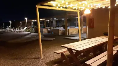 a wooden picnic table under a pavilion at night at Solé Paracas in Paracas