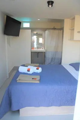 a large blue bed in a room with a sink at Solé Paracas in Paracas