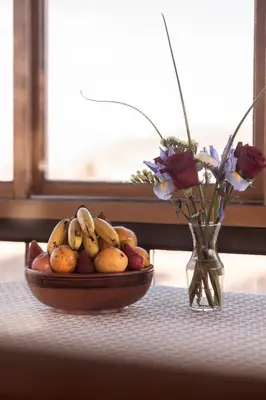 a bowl of fruit on a table next to a vase with flowers at MOAF Cusco Boutique Hotel in Cusco