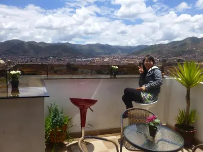 a woman sitting on the ledge of a balcony talking on a cell phone at Hostal Casa Del Inka in Cusco