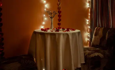 a table with a vase of flowers and lights at Hostal Casa Del Inka in Cusco