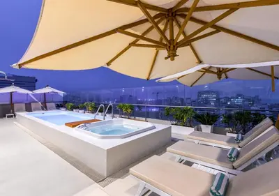 a hot tub on the roof of a building with umbrellas at Dazzler by Wyndham Lima San Isidro in Lima